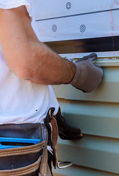 Contractor installing vinyl PVC siding.