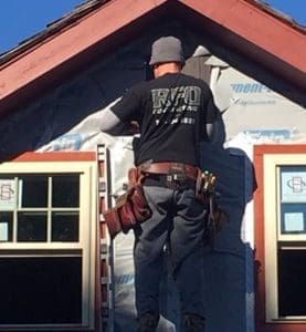 A worker installing siding.